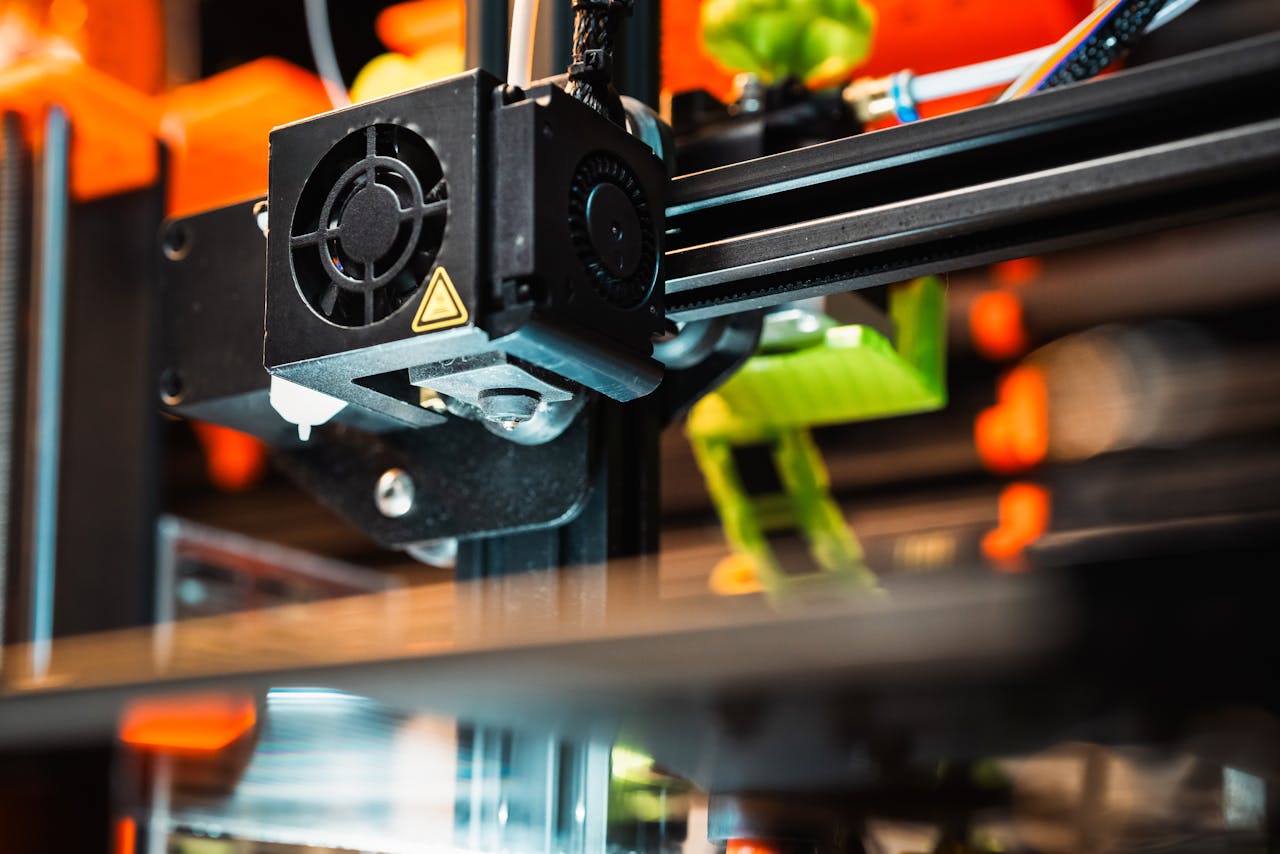 Detailed view of a 3D printer nozzle working in a modern manufacturing setting.